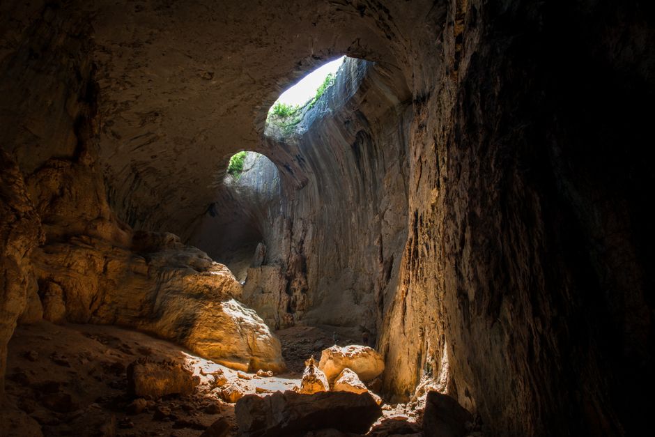 Theth Cave entrance Albania limestone arch sunlight